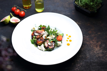 Salad with figs and goat cheese. A plate with an appetizing dish. Application suggestion. Culinary photography, food stylization.