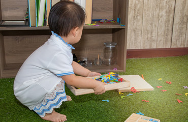 Curiosity Asian toddler lovely girl naughty cheerful play alone in father home office, smiling...