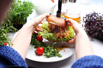 Burger with beef, cheese and vegetables. A plate with an appetizing dish. Application suggestion. Culinary photography, food stylization.