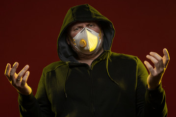 adult man with a beard in a hood and in a protective mask on his face with different emotions,...