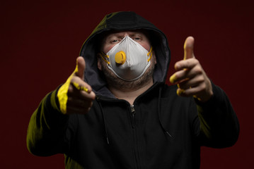 adult man with a beard in a hood and in a protective mask on his face with different emotions,...