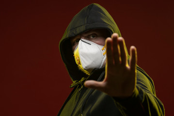 adult man with a beard in a hood and in a protective mask on his face with different emotions,...