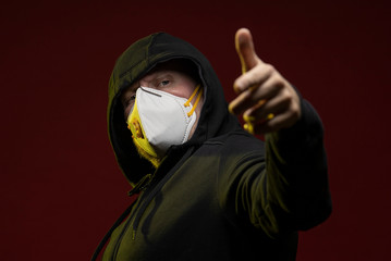 adult man with a beard in a hood and in a protective mask on his face with different emotions,...