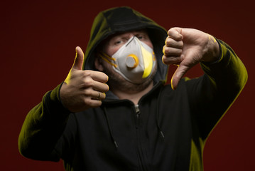 adult man with a beard in a hood and in a protective mask on his face with different emotions,...