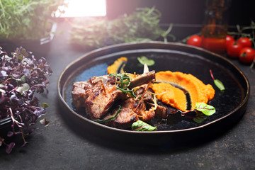 Lamb ribs with pumpkin mousse. A plate with an appetizing dish. Application suggestion. Culinary photography, food stylization.