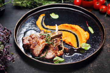 Lamb with carrot mousse. A plate with an appetizing dish. Application suggestion. Culinary photography, food stylization.