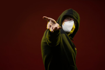 adult man with a beard in a hood and in a protective mask on his face with different emotions,...