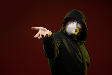 adult man with a beard in a hood and in a protective mask on his face with different emotions,...