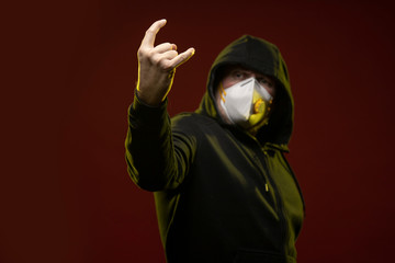 adult man with a beard in a hood and in a protective mask on his face with different emotions,...