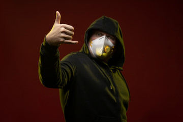adult man with a beard in a hood and in a protective mask on his face with different emotions,...