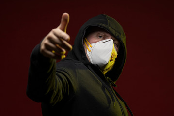 adult man with a beard in a hood and in a protective mask on his face with different emotions,...