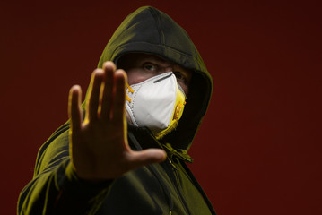 adult man with a beard in a hood and in a protective mask on his face with different emotions,...