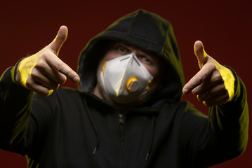 adult man with a beard in a hood and in a protective mask on his face with different emotions,...