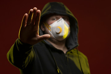 adult man with a beard in a hood and in a protective mask on his face with different emotions,...