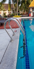 Closeup of stainless steel ladder of swimming pool.
