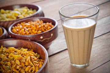 Close-up of fried snacks in bowls with glass of tea
