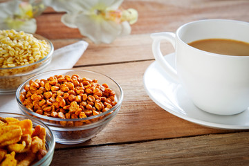Close-up of fried snacks in bowls with cup of tea
