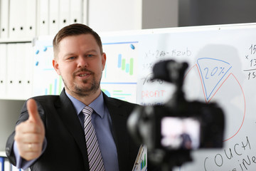 Male in suit and tie show confirm sign arm making promo videoblog or photo session in office...