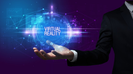 Obraz premium Man hand holding VIRTUAL REALITY inscription, technology concept