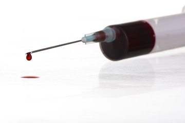 Macro view of drop of blood from syringe