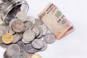 coins in a mason jar over white background
