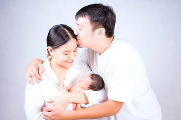 Parents carrying baby. portrait of young family with little son. selective focus of of happy young father kiss mother and hugging infant baby.