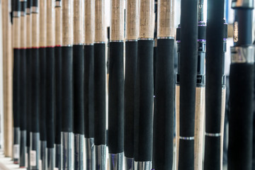 Obraz premium different rods and spinning rods for fishing on the counter in the store. Shallow depth of field