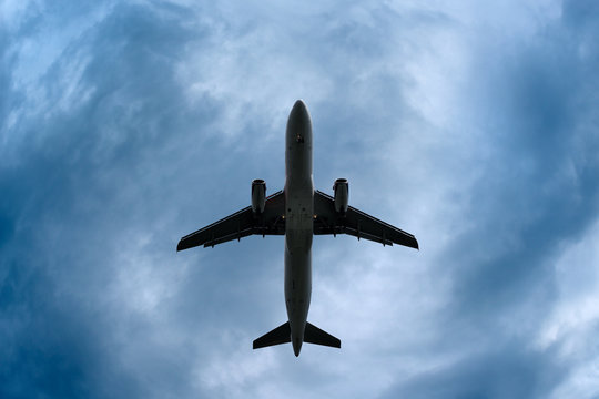 Airplane In A Dramatic Stormy Sky, Low Angle, United Kingdom