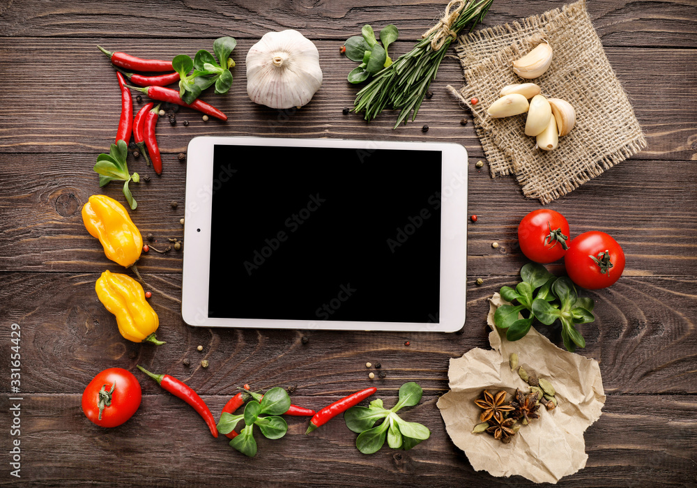 Wall mural Top view of tablet, vegetables and spices on wooden background - Wall murals