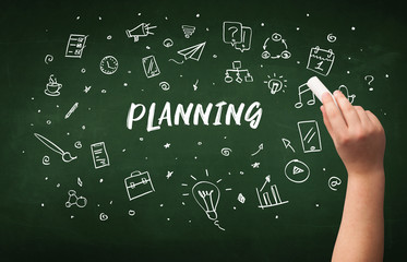 Hand drawing PLANNING inscription with white chalk on blackboard, education concept