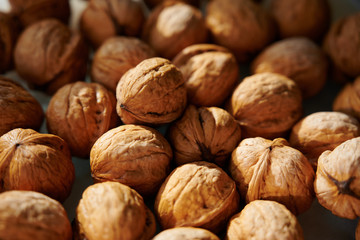 Whole walnuts, close-up shot in harsh sunlight.