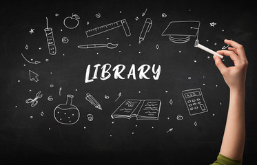 Hand drawing LIBRARY inscription with white chalk on blackboard, education concept