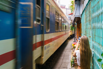 Tourist taking photo of train passing old town in Hanoi