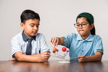 Indian school boy and girl or science student in uniform Using Molecular Model Kit for studying...