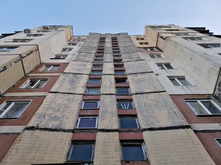 Symmetric facade of old soviet multistorey typical concrete apartment.