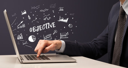 Businessman working on laptop with OBJECTIVE inscription, modern business concept