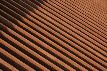 Sunlight and shadow on surface of the old artificial wooden lath in abstract diagonal pattern and perspective view for background design and architecture concept