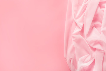 Tender pink silk softly draped on pink background