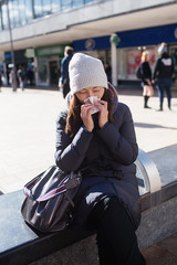 Fototapeta premium Nice Asian young woman wiping her nose in the sreet
