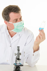 side view of male scientist in chemistry laboratory researcher holds test tube with coronavirus virus analysis and medicine to fight the epidemic covid-19