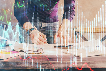 Multi exposure of man standing and planing investment with stock market forex chart.