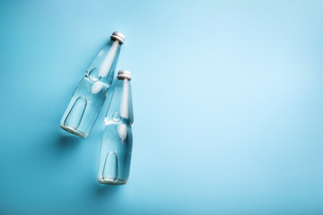 Glass water bottles on blue background