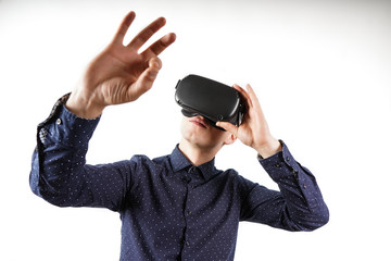 Young man wearing virtual reality glasses during a working break. Behind them is a pure white background.
