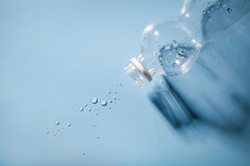 Empty plastic water bottle on blue background
