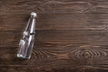 Glass water bottle on wooden background