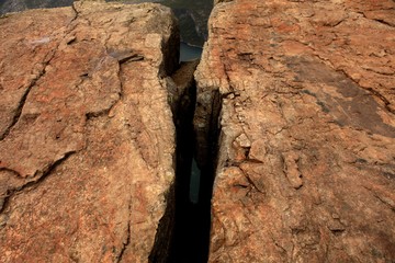 big fault or scratch on the rock. brown rock structure close up. Pile of big granite stones. Texture on the rock surface. Massive stone with scratches on the surface, monochromatic.