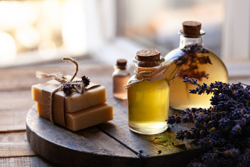 Concept of natural organic oil in cosmetology. Moisturizing skin care and aromatherapy. Gentle body treatment. Handmade soap. Atmosphere of harmony relax. Wooden background, lavender flower copy space - obrazy, fototapety, plakaty