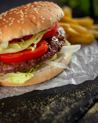 Tasty burger with tomatoes and lettuce