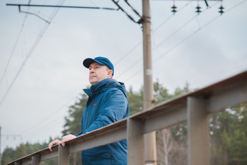 Senior man thinking about his life on Railway, Mature man psychology 