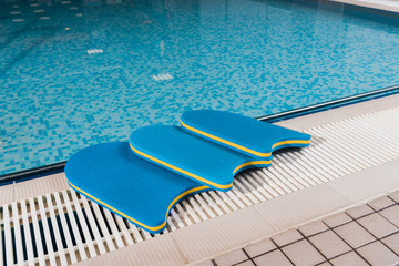 blue flutter boards near swimming pool in sports center